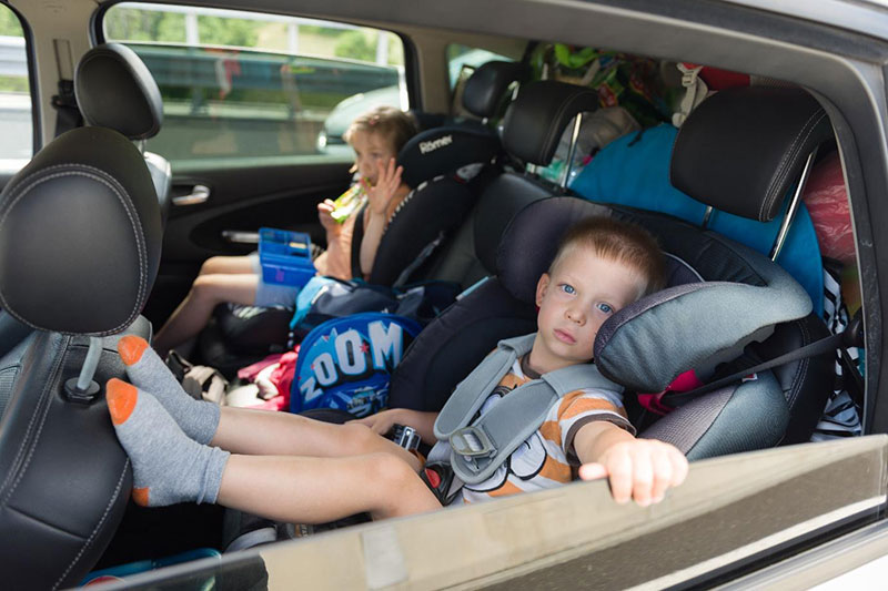 Rodzeństwie w samochodzie, podróż z rodzicami, fotelik dziecięcy